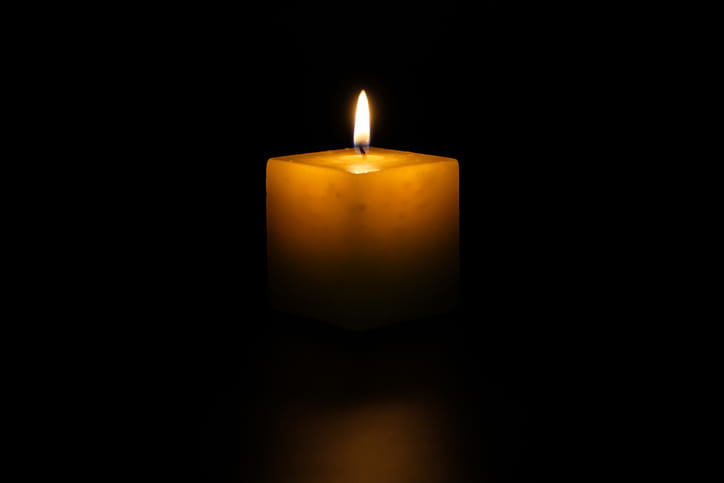 Lit Candle Glowing In Darkness, Symbolizing Mourning And Wrongful Death Case
